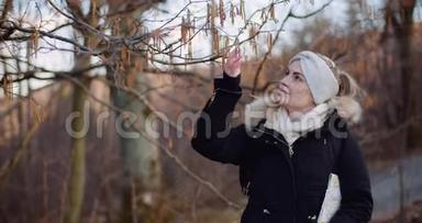 在公园散步时触摸树枝的女人